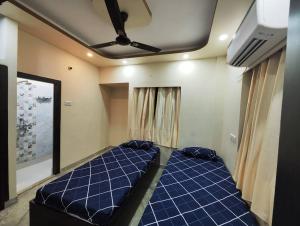 uma grande cama azul num quarto com tecto em Lavish 2BHK, 10 mins from AMRI Hospital Dhakuria em Calcutá