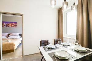 a dining room with a table and a mirror at Apartments / 10 min from center / O2 ARENA in Prague