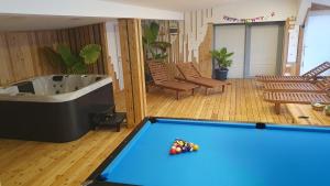 a pool table in a living room with a tub at Apartments Akacijev Izvir in Miklavž na Dravskem Polju