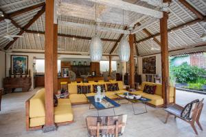 a large living room with yellow couches and tables at Wayang Retreat in Canggu