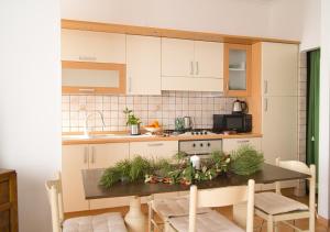 a kitchen with white cabinets and a table with plants at Iris Apartment, Parco Velino Sirente in Celano