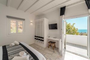 a bedroom with a bed and a view of the ocean at Mr & Mrs White Mykonos in Platis Gialos