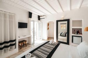 a bedroom with white walls and a bed in a room at Mr & Mrs White Mykonos in Platis Gialos