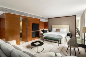 um quarto de hotel com uma cama e uma sala de estar em COMO The Halkin em Londres