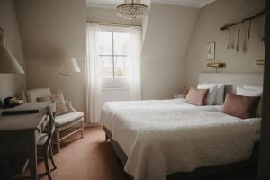 1 dormitorio con cama, escritorio y ventana en Engsholms Slott - Adults Only, en Mörkö