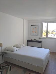 um quarto branco com uma cama e uma janela em Appartement 3 pièces avec parking couvert gratuit. em Le Pré-Saint-Gervais