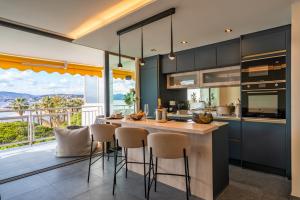 una cocina con una isla con taburetes en Palm croisette front de mer1, en Cannes