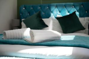 1 cama con almohadas blancas y cabecero azul en Stylish Beachfront Bolthole with Stunning Sea Views and Luxury Touches, en Herne Bay