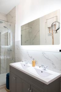 a bathroom with a sink and a mirror and a shower at Stylish Beachfront Bolthole with Stunning Sea Views and Luxury Touches in Herne Bay
