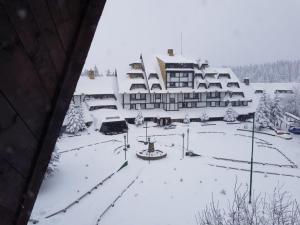 un complejo con nieve en el suelo y edificios en Snow White apartments en Kopaonik