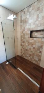 um chuveiro com uma porta de vidro num quarto em Arraia Suítes Pousada em Pipa
