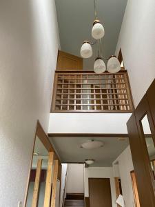 a room with a staircase with a light and a ceiling at HIROSAKI清水森はうす in Hirosaki