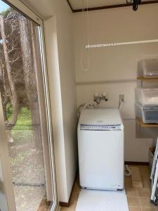 弘前市にあるHIROSAKI清水森はうすの窓付きの客室で、小さな洗濯機が備わります。