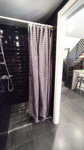 ein Badezimmer mit einem Duschvorhang neben einer Ziegelmauer in der Unterkunft Plaza de Toros de Madrid in Madrid