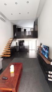 ein Wohnzimmer mit einem Tisch, einem TV und einer Treppe in der Unterkunft Plaza de Toros de Madrid in Madrid