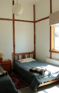 Casa Bike في بونتا أريناس: غرفة نوم بسرير مع اطار خشبي