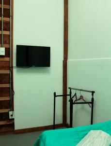 プンタ・アレナスにあるCasa Bikeのベッドルーム1室(ベッド1台、壁にテレビ付)