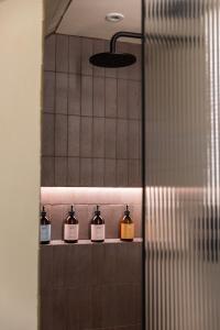 a row of bottles on a shelf in a bathroom at ALTIDO Contemporary cottage with parking in Edinburgh