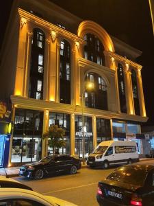 Midyat的住宿－Asur Imperıal Hotel，一座大型建筑,前面有汽车停放