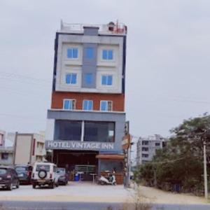 蒂鲁帕蒂Hotel Vintage inn的一座高楼，停车场里停满了汽车