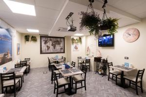 a dining room with tables and chairs and a tv at Rooms Boutique Carducci in Trieste