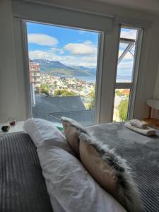 1 cama con almohadas frente a una ventana grande en Ushuaia y Vos en Ushuaia