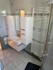 a white bathroom with a sink and a shower at Entre Lac et Montagne 4/6 personnes in Gérardmer