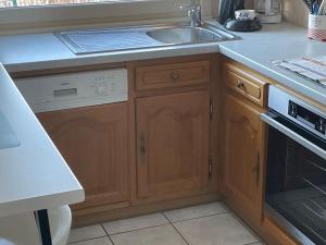 a kitchen with a sink and a stove at Entre Lac et Montagne 4/6 personnes in Gérardmer