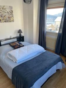 a bedroom with a large bed with a large window at Entre Lac et Montagne 4/6 personnes in Gérardmer