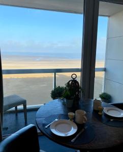 een tafel met twee borden en uitzicht op de oceaan bij Sea and Dunes in Knokke-Heist