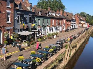 a street with tables and chairs next to a river at Riverside 2 bed apartment Bewdley Worcestershire in Bewdley