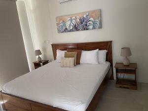 a bedroom with a large bed with white sheets at Perfect combination between nature and fun in Jacó