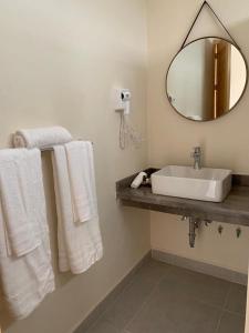 y baño con lavabo, espejo y toallas. en CASA RIVERA DE MORAS en San Luis Soyatlán
