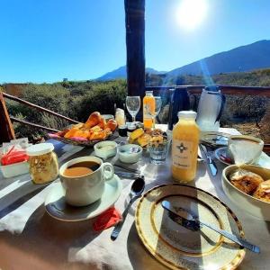 - une table avec petit-déjeuner et une tasse de café dans l'établissement Cabañas Taos Pueblo, à Capilla del Monte
