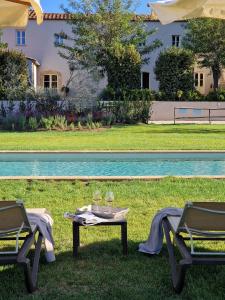 a table and chairs in the grass next to a pool at Tenuta Santa Caterina in Portoferraio