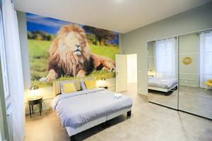 ein Schlafzimmer mit einem Löwenbild an der Wand in der Unterkunft La Jungle, T5 hypercentre chic et cosy, wifi, netflix par SOVALFI in Saint-Étienne