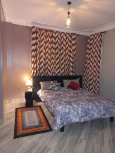 ein Schlafzimmer mit einem Bett und einer großen Wand in der Unterkunft nostiQ homes in Kampala
