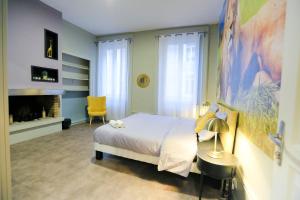 - une chambre avec un lit blanc et une cheminée dans l'établissement La Jungle, T5 hypercentre chic et cosy, wifi, netflix par SOVALFI, à Saint-Étienne