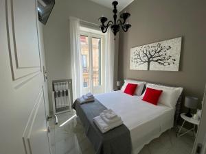 sypialnia z dużym białym łóżkiem z czerwonymi poduszkami w obiekcie La Fitolacca B&B w mieście Lecce