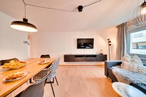 a living room with a dining table and a tv at Stuttgart am Wasen Toplage 4Zi 80qm in Stuttgart