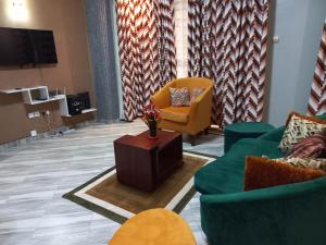 a lobby with two couches and a chair and a table at nostiQ homes in Kampala