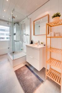 ein Bad mit einem Waschbecken, einer Dusche und einem Spiegel in der Unterkunft Stuttgart am Wasen Toplage 4Zi 80qm in Stuttgart