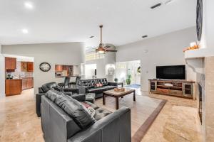 a living room with leather couches and a tv at Outdoor Oasis by Beaches in Gulf Breeze