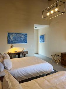 1 dormitorio con 2 camas, mesa y lavamanos en CASA RIVERA DE MORAS en San Luis Soyatlán