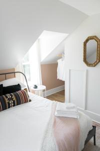 a bedroom with a white bed and a mirror at Downtown Picton 2-Bedroom Boho Suite! in Picton