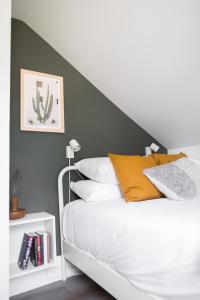 a bedroom with a white bed with a black accent wall at Downtown Picton 2-Bedroom Boho Suite! in Picton