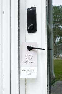a door with a card and a phone on it at Downtown Picton 2-Bedroom Boho Suite! in Picton