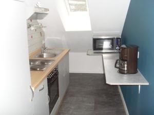 a small kitchen with a sink and a microwave at Ferienwohnung am Waldrand in Schmallenberg