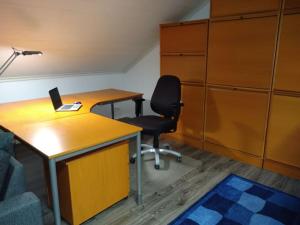 een kantoor met een bureau, een stoel en een laptop bij Penthouse with a balcony in Hyvinkää