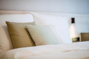 Una cama blanca con una almohada. en Schafalm Dahoam, en Schladming